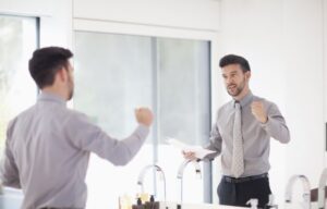 Mid-adult-businessman-practicing-presentation-in-mirror-ss