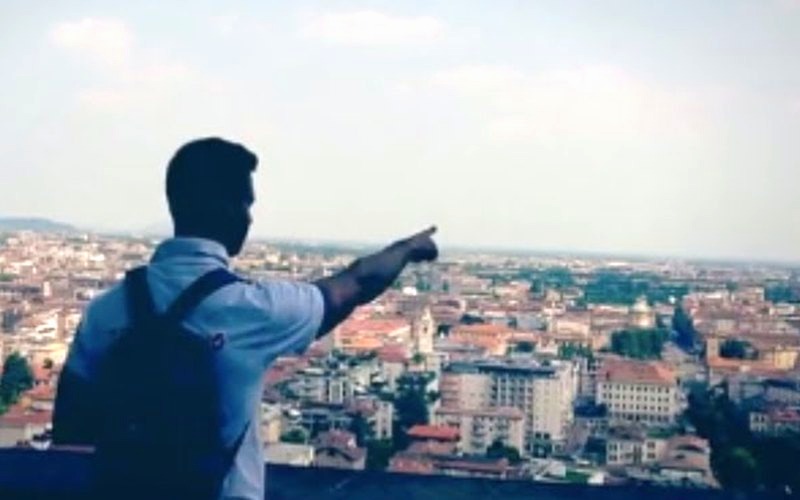 Partecipante indica il panorama dalla Città Alta di Bergamo