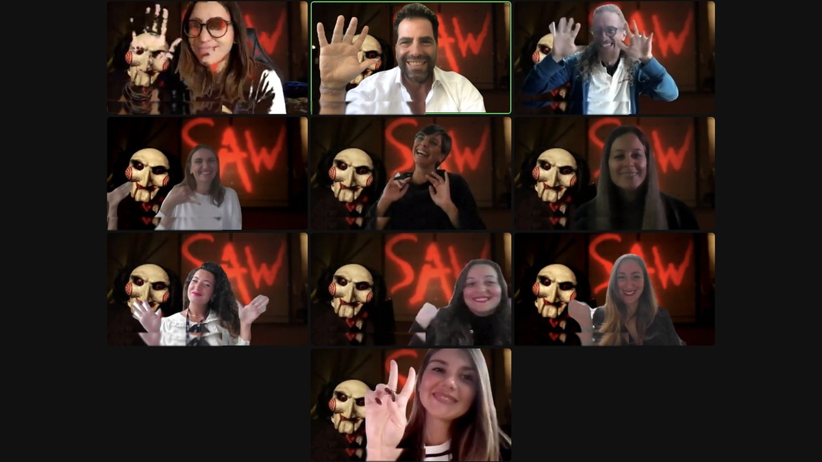 Dieci partecipanti in videochiamata, tutti con la maschera dell’Enigmista come sfondo, salutano alla fine di una escape room online
