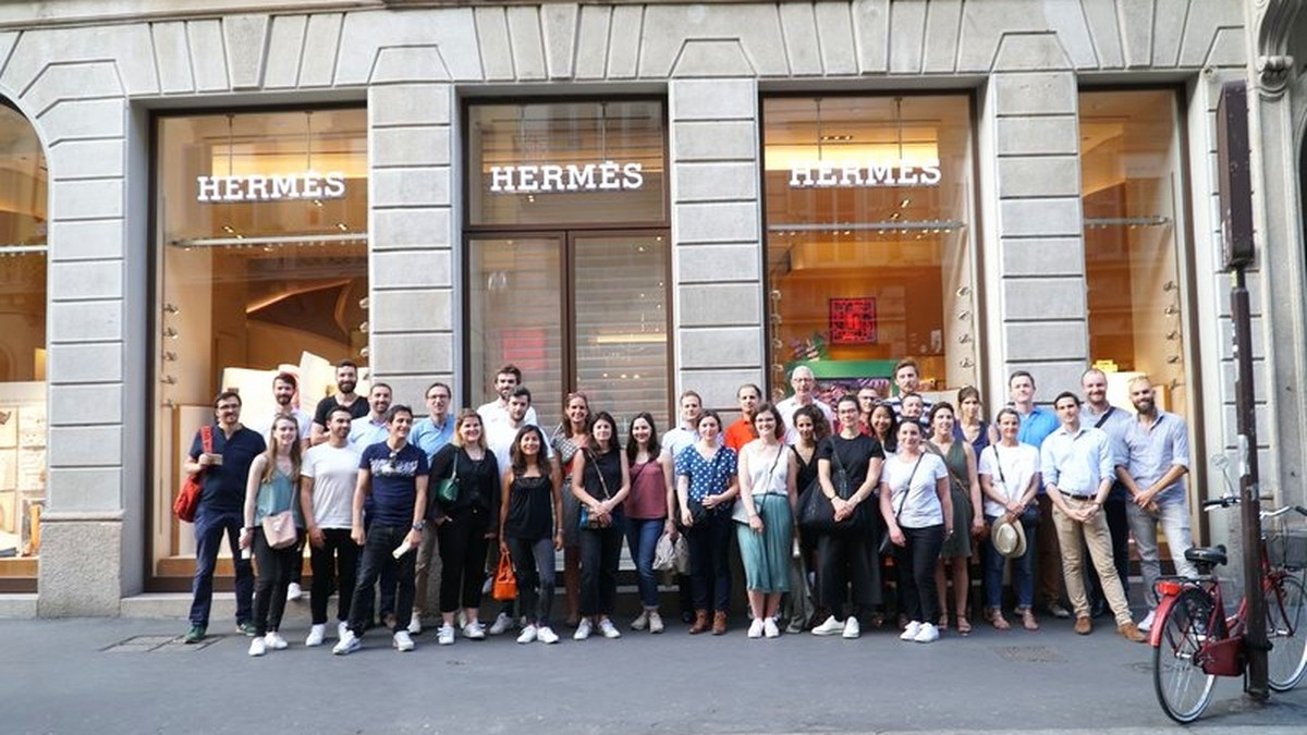 Un gruppo numeroso in posa in via Montenapoleone a Milano, davanti alle vetrine