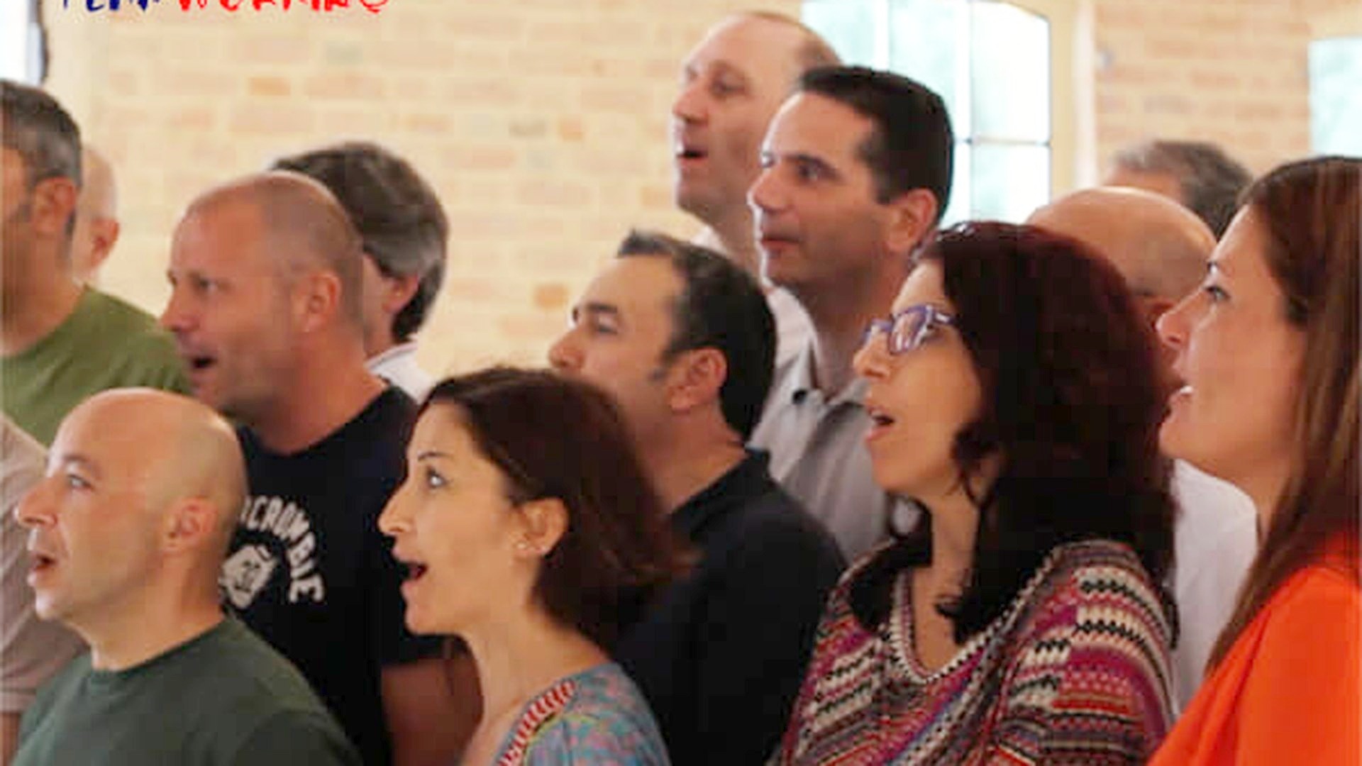 Coro aziendale che canta in sala con il direttore davanti