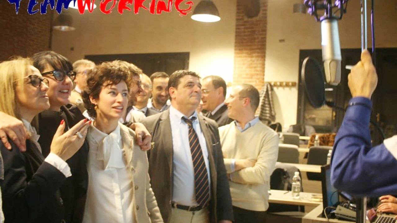 Il gruppo canta insieme al microfono durante la registrazione