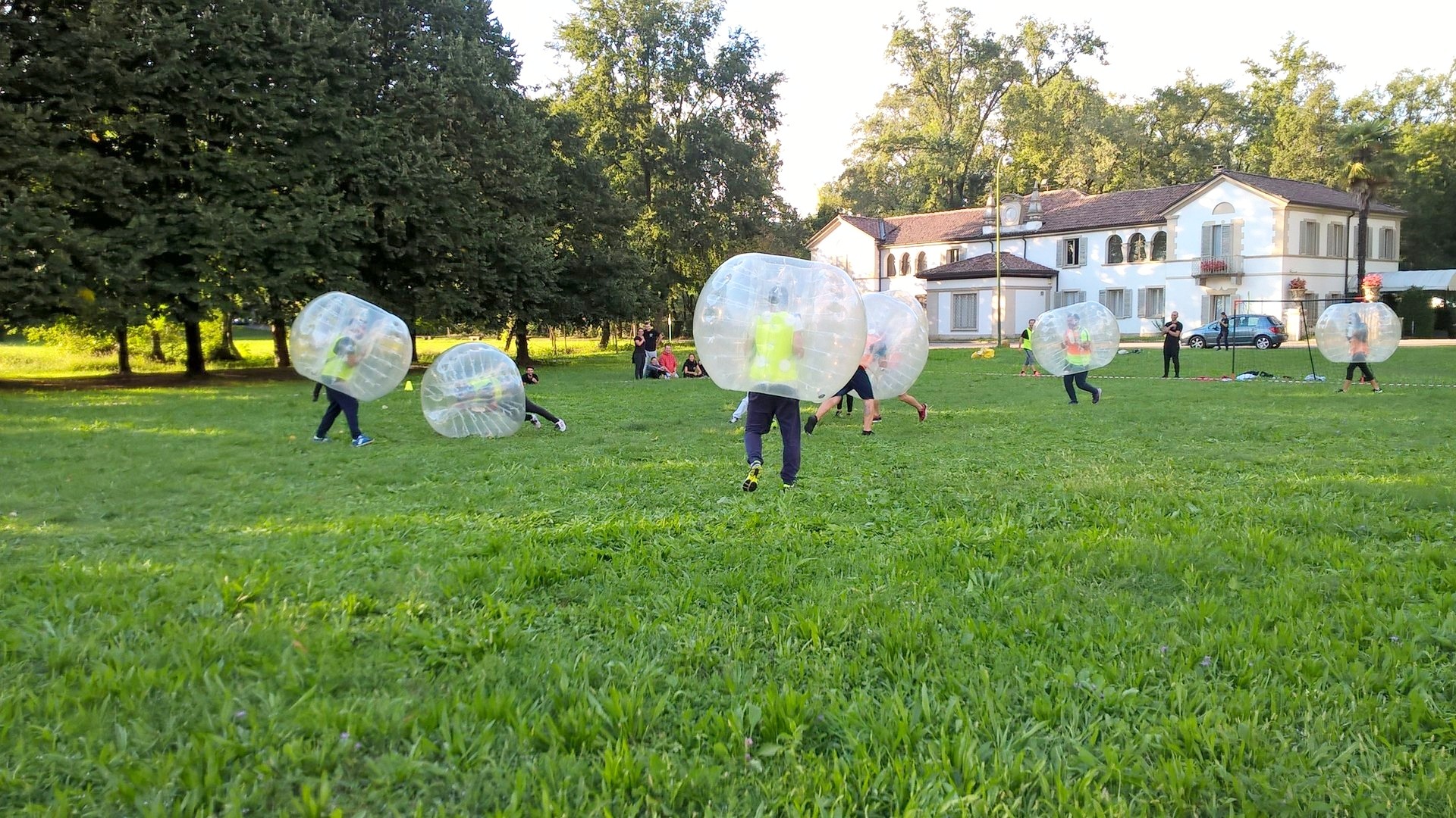 Partecipanti dentro sfere gonfiabili trasparenti si scontrano su un prato