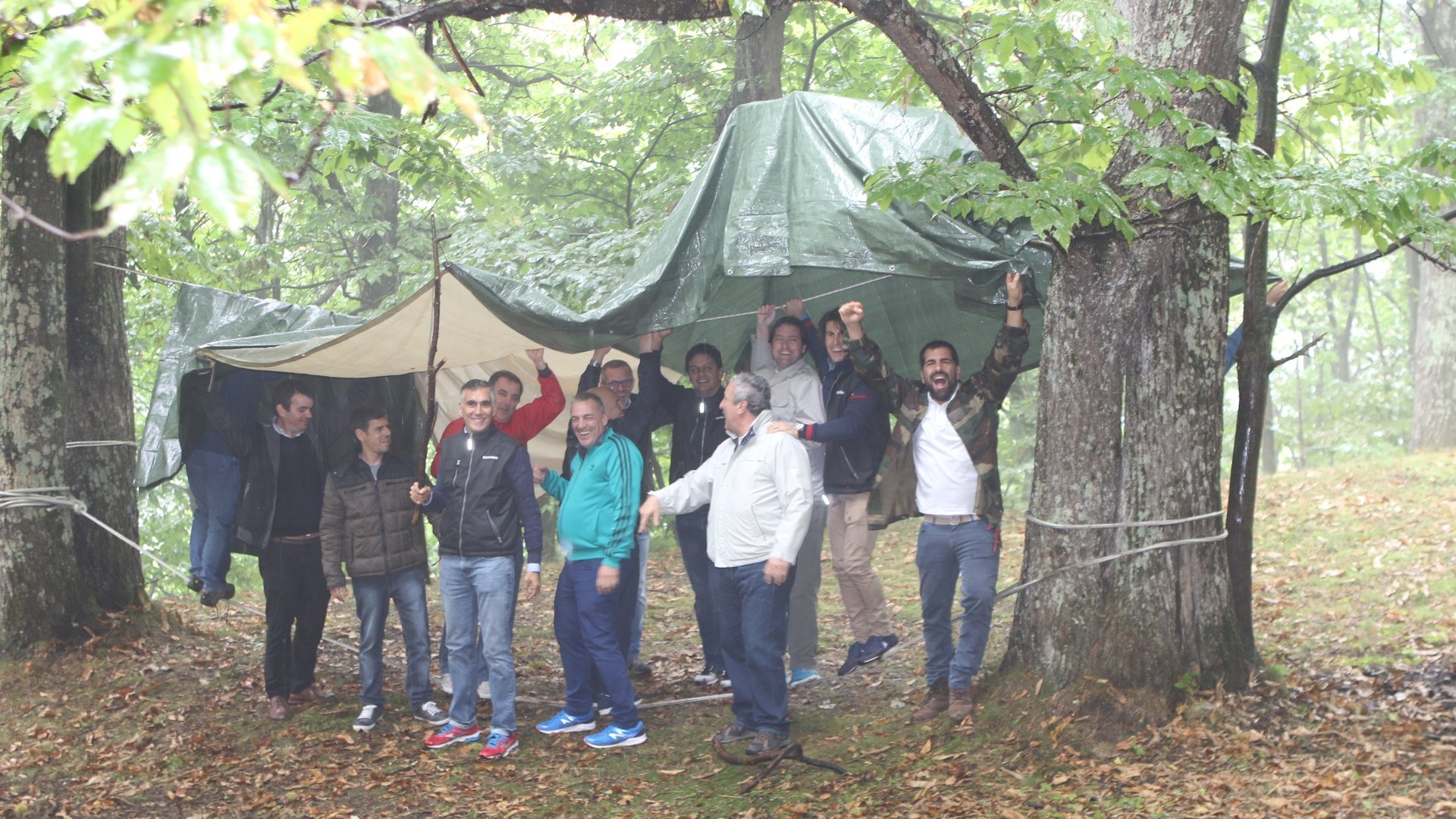 Squadra schierata davanti al riparo di teli e corde costruito nel bosco