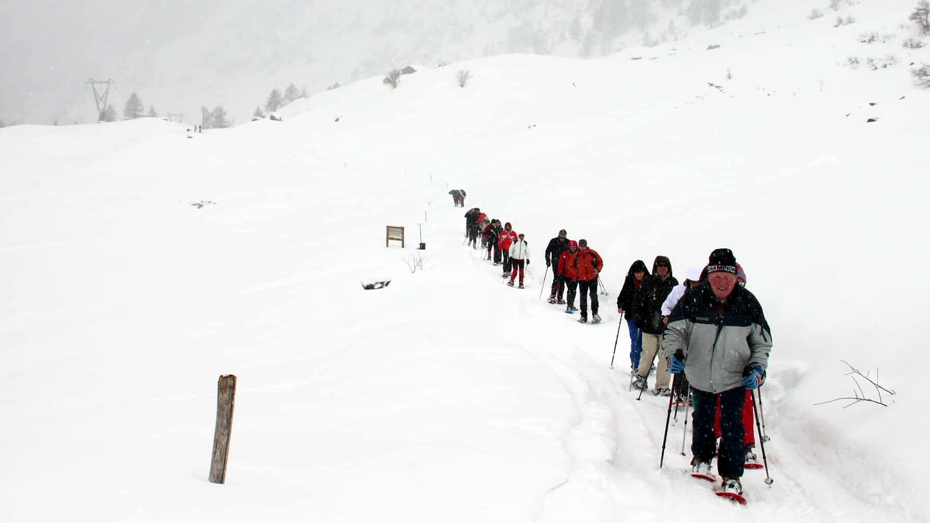 Un gruppo in fila sulla neve durante un trasferimento in quota