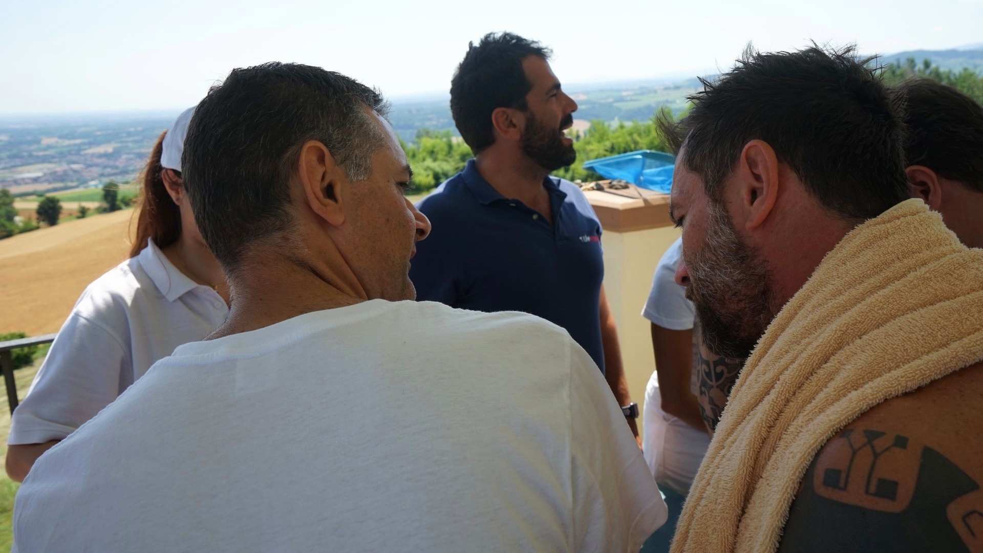 Molte mani lavorano insieme allo stesso scafo di cartone, ognuna su un pezzo diverso