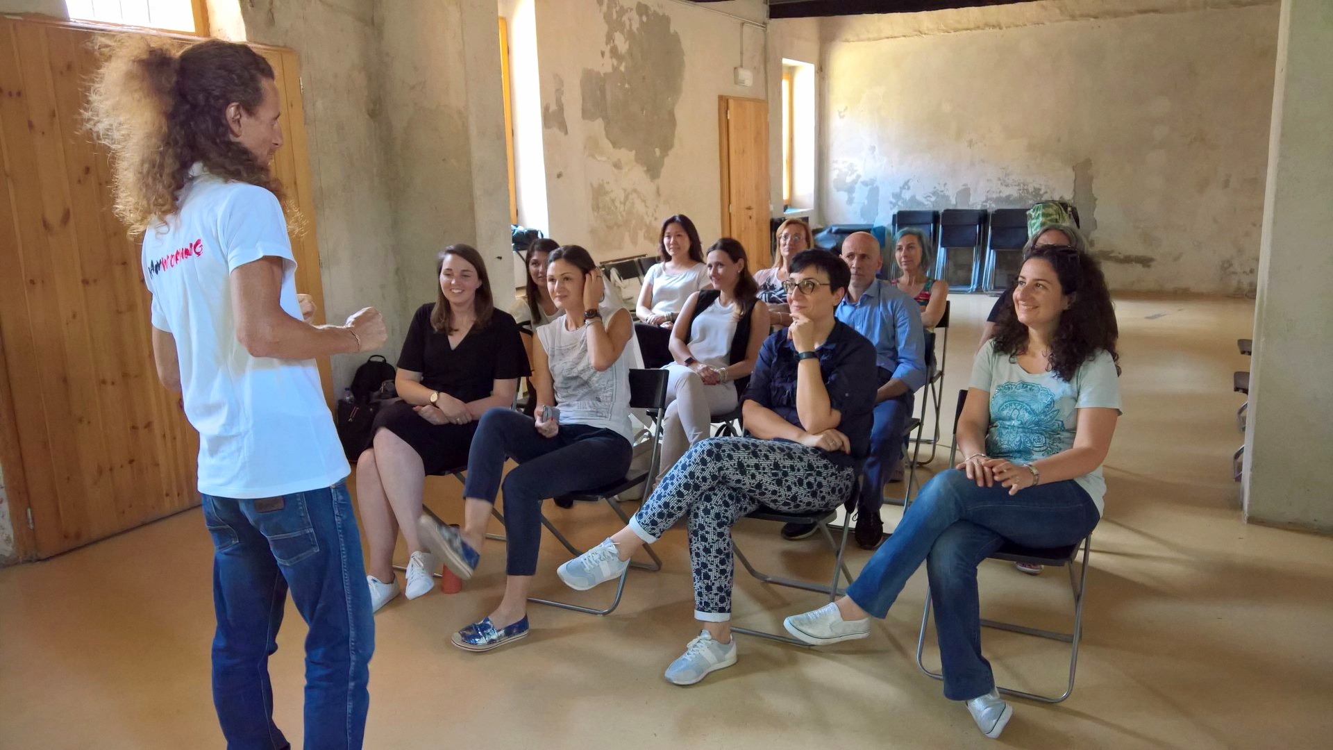 Gruppo seduto in cerchio ascolta il formatore durante una sessione di team coaching