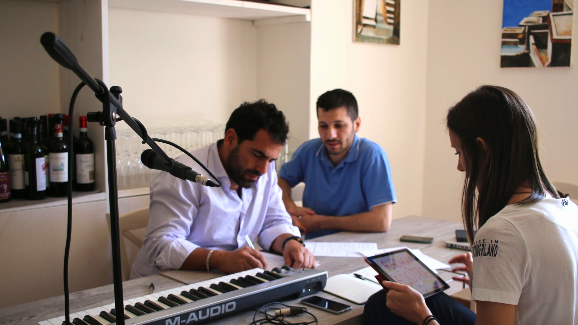 Partecipanti scrivono il testo al tavolo di regia con tastiera e microfoni
