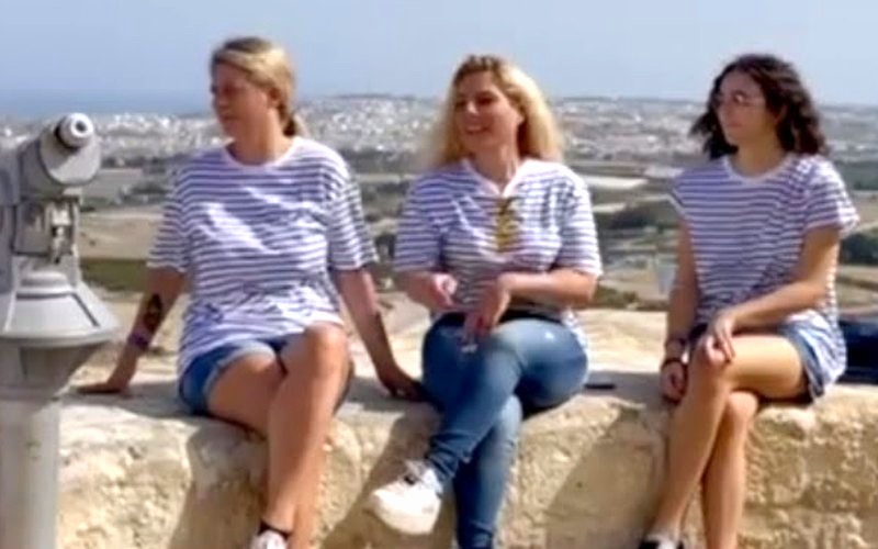 Partecipanti sedute sulle mura con Malta alle spalle