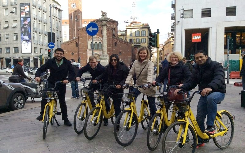 Squadra in bici a noleggio in una via di Milano durante un Urban Game