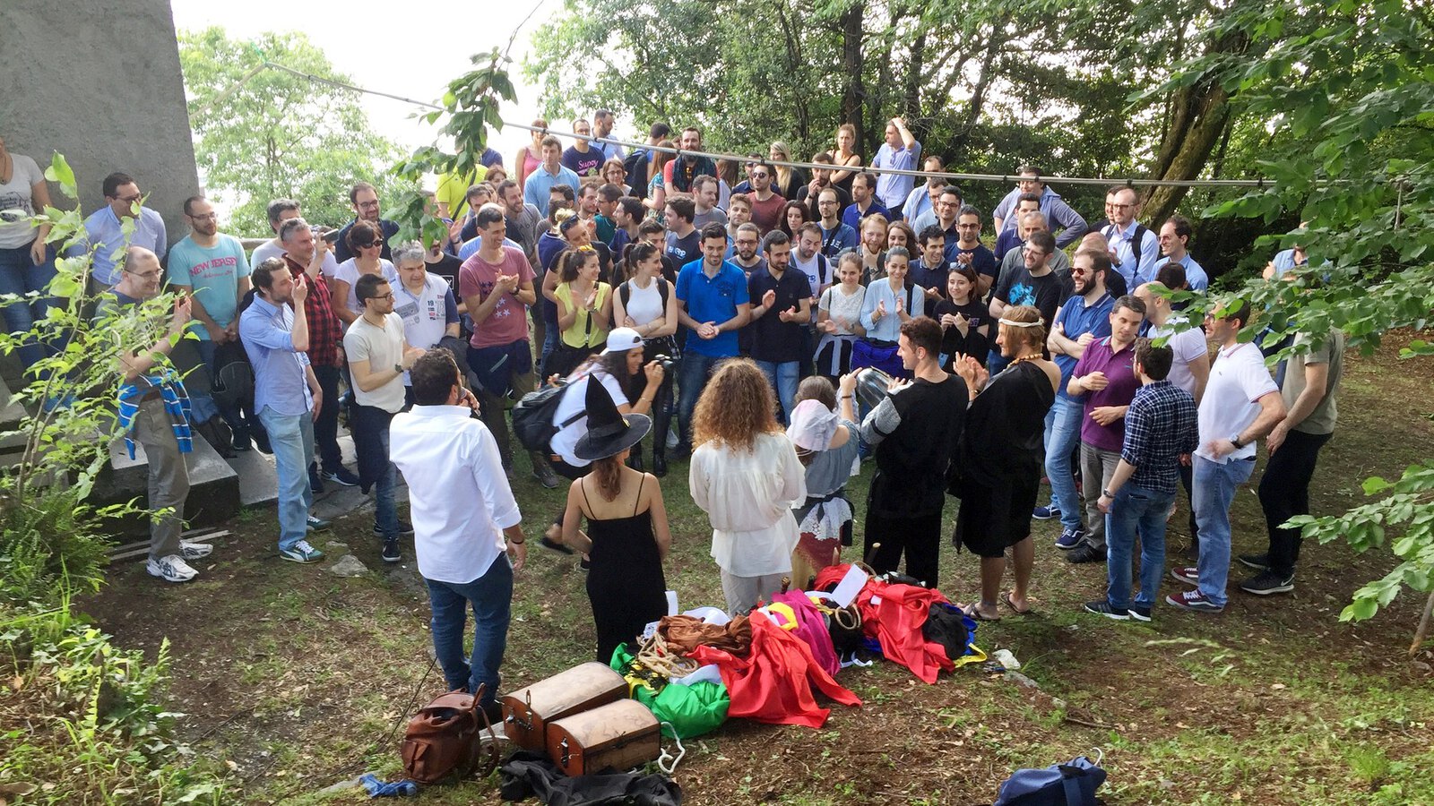 Un gruppo numeroso riunito allaperto attorno alla scena di un team building